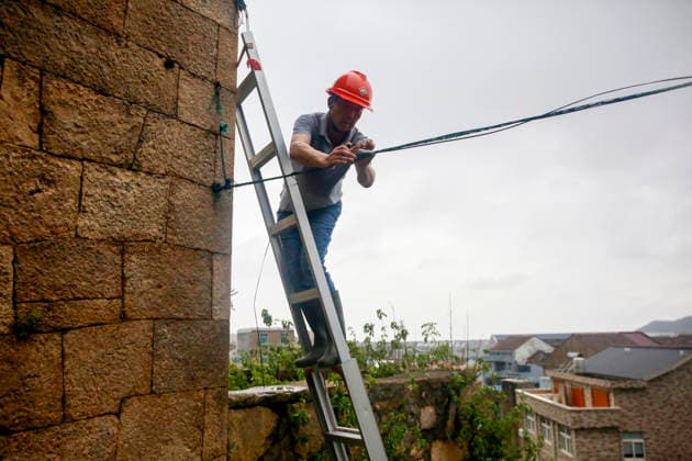 WENLING, CHINA - AUGUST 10: A staff member repairs optical cables damaged by Typhoon Dolphin on August 10, 2026 in Wenling, Zhejiang Province of China. Heavy rainfall brought by Typhoon Dolphin caused severe waterlogging on roads and affecting residents travel. Typhoon Dolphin, the 13th typhoon of the year, made landfall at Yuhuan of Taizhou City, east China s Zhejiang Province, at around 5:30 p.m. on August 9.  Copyright: xVCGx 111659096989