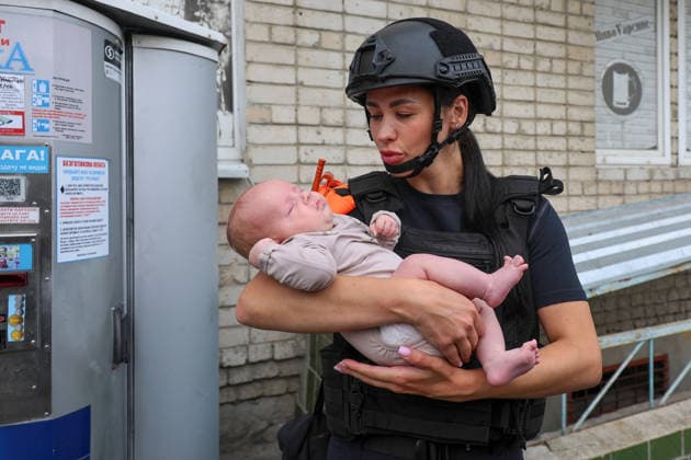 Russian Missile Strikes Apartment Block - Kharkiv A State Emergency Service psychologist holds a baby evacuated from a 10-storey apartment block in the Saltivskyi district hit by a Russian S8000 Banderol cruise missile, Kharkiv, Ukraine, August 9, 2026. As a result of the terrorist attack, the seventh to tenth floors were destroyed. At present, three people are confirmed dead and 37 others injured. Photo by Viacheslav Madiievskyi Ukrinform ABACAPRESS.COM Kharkiv Ukraine  Copyright: xMadiyevskyyxVyacheslav Ukrinformx