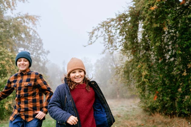 Two happy children run on a foggy autumn day in woodland Corby, England, United Kingdom CR_JNDO260805-2095468-01 ,model released, Symbolfoto ,property released