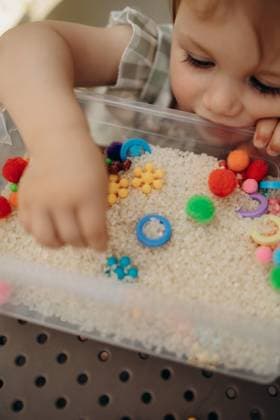 Closeup of toddler hand exploring rice sensory bin Lutsk, Volyn Oblast, Ukraine CR_RDQW260805-2096818-01 ,model released, Symbolfoto ,property released