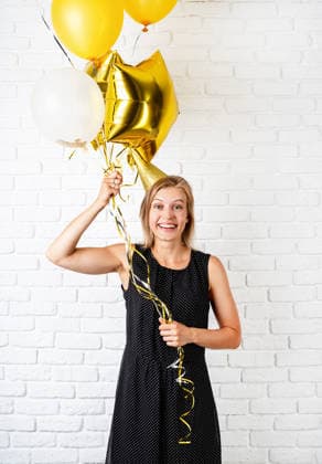 Junge blonde Frau mit Geburtstagshut, die goldene Luftballons in der Hand hält und ihren Geburtstag feiert Birthday party. Young blond smiling woman wearing birthday hat holding golden balloons celebrating birthday (License=RF) ,model released, Symbolfoto Copyright: xZoonar.com IlonaxShorokhovax 25396503 ,model released, Symbolfoto ,property released