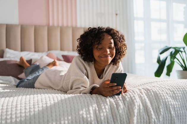 Afrikanisches Mädchen hält Smartphone-Touchscreen tippt scrollen Seite zu Hause. Frau mit Handy surfen im Internet mit Social-Media-Apps spielen Spiel. Einkaufen Online-Internet-Nachrichten Handy-Sucht. African girl holding smartphone touch screen typing scroll page at home. Woman with cell phone surfing internet using social media apps playing game. Shopping online Internet news cellphone addiction (License=RF) ,model released, Symbolfoto Copyright: xZoonar.com IuliiaxZavalishinax 25397718 ,model released, Symbolfoto ,property released