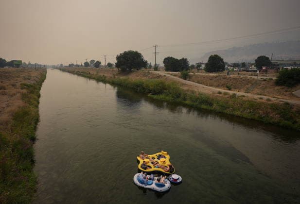 August 10, 2026, Penticton, Bc, CANADA: People float on the Channel Pathway that connects Okanagan Lake and Skaha Lake as smoke from wildfires burning in the region fills the air, in Penticton, B.C., on Monday, Aug. 10, 2026. Penticton CANADA  - ZUMAc35_ 20260810_zaf_c35_025 Copyright: xDarrylxDyckx