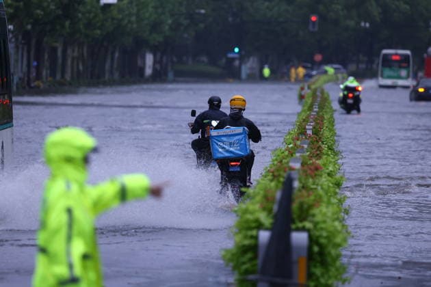 SHANGHAI, CHINA - AUGUST 10: A delivery rider takes an order on Hongqiao Road near the Inner Ring Elevated Road amid heavy rain caused by Typhoon Dolphin on August 10, 2026 in Shanghai, China. The city experienced intense rainfall and strong winds as Typhoon Dolphin made impact, leading to waterlogging on multiple road sections.  Copyright: xVCGx 111659181736