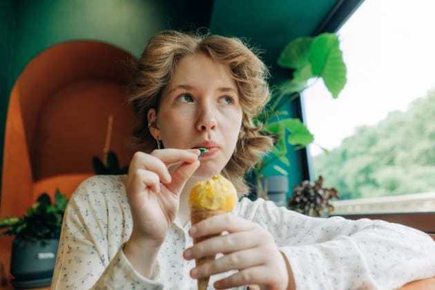 Ein junges Mädchen, das in einem gemütlichen Café nachdenklich am Fenster sitzt und dabei ein Eis genießt Adolescent girl enjoying ice cream cone in a cozy cafe while looking thoughtful by the window (License=RF) ,model released, Symbolfoto Copyright: xZoonar.com TITOVAxILONAx 25411190 ,model released, Symbolfoto ,property released