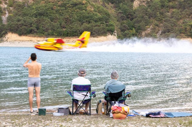 Canadair Aircraft Scoops Water From Lake Monteynard To Fight Fire In Treffort - France People watch as a Canadair aircraft scoops up water from Lake Monteynard to fight a fire in the Drôme, in Treffort, France on August 10, 2026. Photo by Arnaud Bertrand ABACAPRESS.COM Treffort France  Copyright: xBertrandxArnaud ABACAx