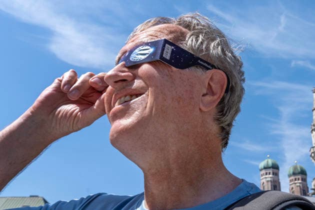 Sonnenfinsternis Brille, stolzer Besitzer einer Schutzbrille auf dem Marienplatz, Brillen sind leider fast überall ausverkauft, riesige Nachfrage wegen der partiellen Sonnenfinsternis morgen Abend, München, 11. August 2026 Deutschland, München, 11. August 2026, Sonnenfinsternis Brille, stolzer Besitzer einer Schutzbrille, schaut auf dem Marienplatz in die Sonne, Mann hat eine der letzten Exemplare im Deutsches Museum Shop am Rindermarkt erstanden, halbe Stunde in einer langen Schlange dafür angestanden, Sonnen-Sicht-Brille kostete nur 3,95 Euro, Brillen sind leider fast überall ausverkauft, riesige Nachfrage wegen der partiellen Sonnenfinsternis morgen Abend, als Augenschutz braucht man eine spezielle Sonnenfinsternisbrille mit CE-Ken