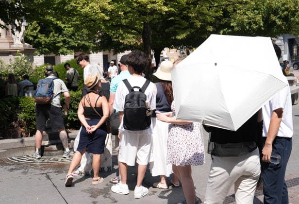 IPA87397535 - Milan, August 11, 2026. It’s hot in Milan. The heat wave continues, and tourists are shielding themselves from the sun with clothing, umbrellas, and hats, and are cooling off or drinking water at the fountain in Piazza Scala.  Copyright: xDuilioxPiaggesix xDuilioxPiaggesix 87397535