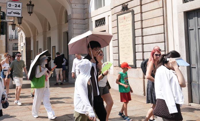 IPA87397515 - Milan, August 11, 2026. It’s hot in Milan. The heat wave continues, and tourists are shielding themselves from the sun with clothing, umbrellas, and hats, and are cooling off or drinking water at the fountain in Piazza Scala.  Copyright: xDuilioxPiaggesix xDuilioxPiaggesix 87397515