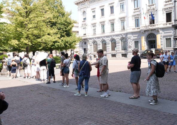 IPA87397523 - Milan, August 11, 2026: It’s hot in Milan. The heat wave continues, and tourists are shielding themselves from the sun with clothing, umbrellas, and hats, and are cooling off or drinking water at the fountain in Piazza Scala.  Copyright: xDuilioxPiaggesix xDuilioxPiaggesix 87397523