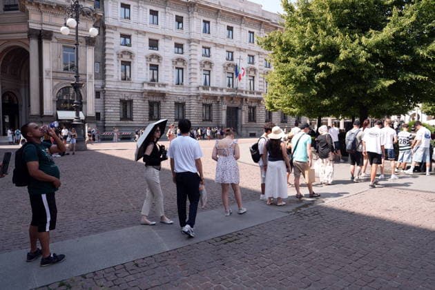 IPA87397525 - Milan, August 11, 2026: It’s hot in Milan. The heat wave continues, and tourists are shielding themselves from the sun with clothing, umbrellas, and hats, and are cooling off or drinking water at the fountain in Piazza Scala.  Copyright: xDuilioxPiaggesix xDuilioxPiaggesix 87397525