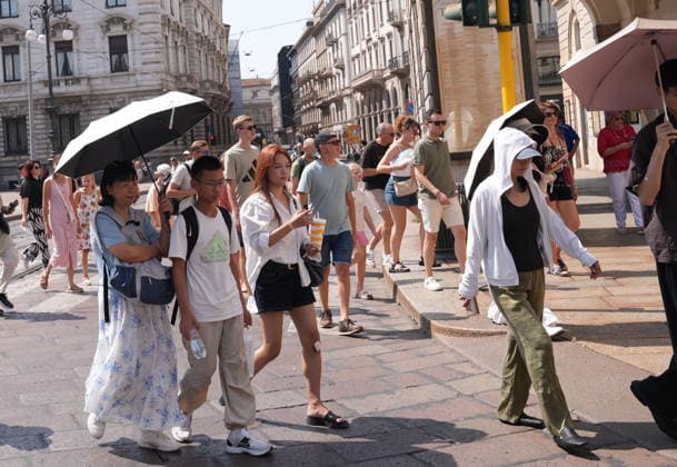 IPA87397528 - Milan, August 11, 2026: It’s hot in Milan. The heat wave continues, and tourists are shielding themselves from the sun with clothing, umbrellas, and hats, and are cooling off or drinking water at the fountain in Piazza Scala.  Copyright: xDuilioxPiaggesix xDuilioxPiaggesix 87397528