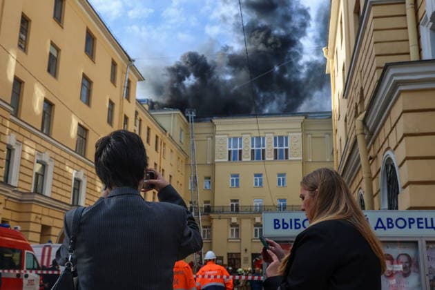 RUSSIA, ST PETERSBURG - AUGUST 11, 2026: Bystanders take pictures of a roof fire at the Vyborgsky Palace of Culture. Valentin Yegorshin TASS  96035947