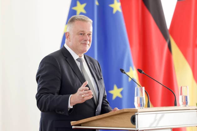 Ministerpräsident Gordon Schnieder am Rednerpult vor Fahnen anlässlich einer Feierstunde zur Verleihung von berufsbezogener Titel in der Staatskanzlei Rheinland-Pfalz 11.08.26 *** Prime Minister Gordon Schnieder at the lectern in front of flags during a ceremony to confer professional titles at the State Chancellery of Rhineland-Palatinate, August 26, 2011
