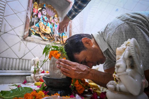 NEW DELHI, INDIA - AUGUST 11: A large number of devotees gather to offer prayers and perform religious rituals on the occasion of Sawan Shivratri at a temple in Karol Bagh on August 11, 2026 in New Delhi, India. Shravan Shivratri is a sacred Hindu festival dedicated to Lord Shiva, observed on the Krishna Paksha Chaturdashi tithi of the holy month of Shravan. The festival commemorates Lord Shiva consuming the Halahala poison to save the universe during the churning of the cosmic ocean. The devotees bath the shivlinga with Gangajal, raw milk, honey, curd, ghee (Panchamrit) and other cooling liquids to help soothe his intense heat. (Photo by Sanchit Khanna Hindustan Times) Devotees Throng Shiva Temples On Occasion Of Shravan Shivratri Festival