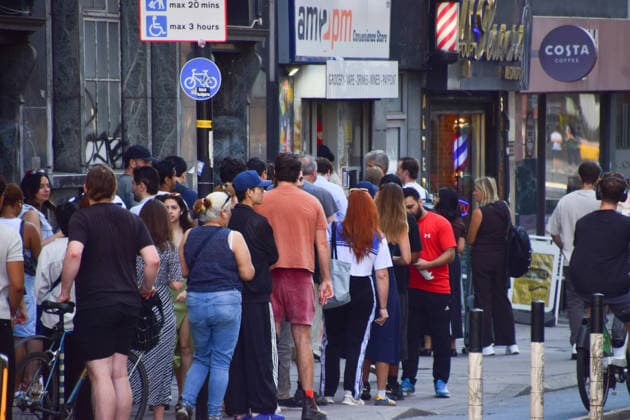 August 12, 2026, London, England, United Kingdom: A long queue forms outside the AM2PM convenience store on Whitechapel High Street in London as people try to snag last-minute solar eclipse glasses ahead of the partial eclipse this evening. London United Kingdom  - ZUMAv130 20260812_zip_v130_005 Copyright: xVukxValcicx