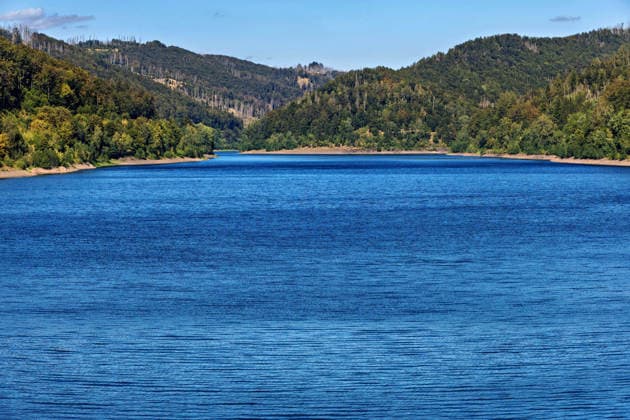 12.08.2026 Blick auf das Wasser der Odertalsperre bei Bad Lauterberg im Landkreis Göttingen in Niedersachsen. Sie ist die südlichste Talsperre der Harzwasserwerke und wurde in den Jahren 1930 - 1933 erbaut und 1934 in Betrieb genommen. Mit einem Staudamm von 310 Meter Länge bietet die Talsperre vor allem Hochwasserschutz für die Region um Bad Lauterberg und kann bis zu 30,6 Millionen m3 Wasser speichern. Neben dem Hochwasserschutz gibt die Talsperre bei der Niedrigwassererhöhung außerdem Wasser an Unterlauf der Oder ab und schützt damit Flora und Fauna im Lebensraum Fluss. Bad Lauterberg Niedersachsen Deutschland *** August 12, 2026: View of the water at the Oder Dam near Bad Lauterberg in the district of Göttingen, Lower Saxony.