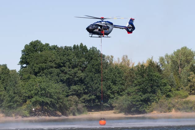 Plauen - Polizeihubschrauber unterstützen Löscharbeiten bei Waldbrand in Plauen Plauen, Meßbach, Messbach, Vogtland, Sachsen, Waldbrand, Vegetationsbrand, Feuerwehr, Löscharbeiten, Polizeihubschrauber, Polizei Sachsen, sächsische Polizei, H145, Airbus H145, Löschhubschrauber, Hubschrauber, Luftunterstützung, Bambi Bucket, Löschwasserbehälter, Außenlast, Wasseraufnahme, Wasserabwurf, Talsperre Pirk, Pirk, Katastrophenschutz, Einsatz, Brandbekämpfung, Glutnester, wildfire, forest fire, firefighting helicopter, aerial firefighting Plauen Sachsen Deutschland *** Plauen Police Helicopters Assist in Firefighting Efforts During a Wildfire in Plauen Plauen, Meßbach, Messbach, Vogtland, Saxony, wildfire, vegetation fire, fire department, Copyright: xEHLxMediax 20260812_plauen-waldbrand-hubschrauber_8