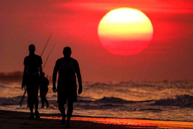 August 12, 2026, Isle Of Palms, Sc, United States: People silhouetted by the sunrise, walk along the beach as the massive ball rises over the Atlantic Ocean, August 12, 2026 in Isle of Palms, South Carolina. The Charleston area is currently under a heat advisory with temperatures in the 90Ã¢â‚¬â ¢s and a heat index of 115-degrees. Isle Of Palms United States - ZUMAe02_ 20260812_zaf_e02_005 Copyright: xRichardxEllisx
