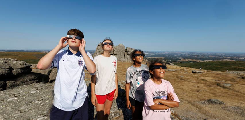 Solar eclipse, Haytor Dartmoor, Devon, UK - 12 Aug 2026 NEWS - Finley, Freya,Nailah and Zahra look towards. the sun with their special solar glasses to watch the eclipse at Haytor Rock ahead of the solar eclipse from Haytor, Dartmoor, Devon where people will come to view the eclipse on 12th August 2026. Haytor Dartmoor Devon GBR Copyright: xPhilxMingo PPAUKx PPA-297127