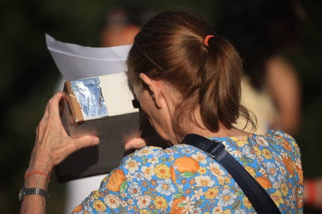 August 12, 2026, London, London, UK: London, UK. People wearing protective glasses watch a solar eclipse in Greenwich as the Moon passes in front of the Sun and blocks its light. In London, more than 90% of the Sun is covered at the peak of the eclipse. The eclipse takes place across the UK from 18:17 to 20:06, reaching its maximum at 19:12. London UK  - ZUMAl94_ 20260812_zaf_l94_035 Copyright: xMarcinxNowakx
