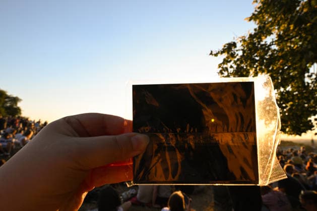 Hundreds Gather At Krakow s Historic Krakus Mound To Watch Solar Eclipse KRAKOW, POLAND - AUGUST 12: A spectator holds up a dark solar filter sheet in a protective plastic sleeve to view the sun during a solar eclipse. Hundreds of residents and tourists gathered on the historic Krakus Mound (Kopiec Krakusa) to safely view the rare celestial event over the city. Krakow Poland  Copyright: xArturxWidakx originalFilename: widak-hundreds260812_nphHL.jpg