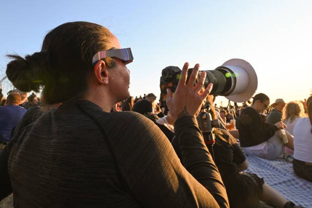 Hundreds Gather At Krakow s Historic Krakus Mound To Watch Solar Eclipse KRAKOW, POLAND - AUGUST 12: A photographer equipped with protective solar glasses adjustments a camera with a telephoto lens and custom solar filter to document the rare celestial event. Hundreds of residents and tourists gathered across the historic Krakus Mound (Kopiec Krakusa) to watch the solar eclipse as it cast over the city skyline. Krakow Poland  Copyright: xArturxWidakx originalFilename: widak-hundreds260812_npjd0.jpg