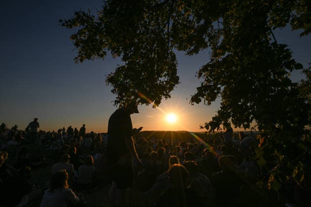 Hundreds Gather At Krakow s Historic Krakus Mound To Watch Solar Eclipse KRAKOW, POLAND - AUGUST 12: Spectators sit in silhouette under overhanging tree branches as the sun dips toward the horizon during a solar eclipse. Hundreds of onlookers gathered on the elevated grassy slopes of the historic Krakus Mound (Kopiec Krakusa) to secure panoramic vantage points for the rare celestial event. Krakow Poland  Copyright: xArturxWidakx originalFilename: widak-hundreds260812_npJul.jpg