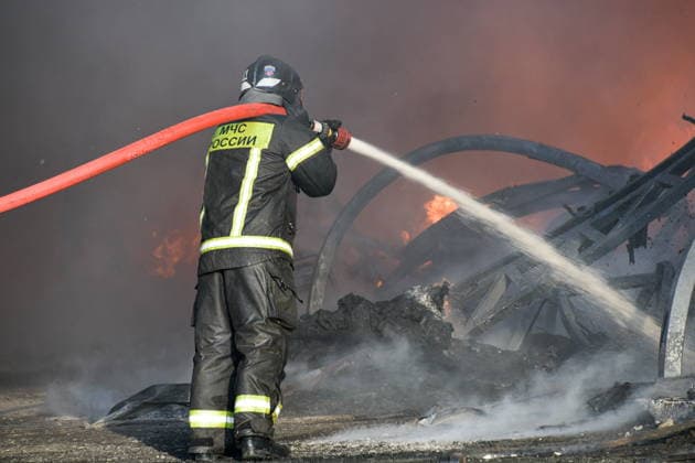 RUSSIA, KRASNODAR REGION - AUGUST 12, 2026: An employee of the Russian Emergencies Minsitry extinguishes a fire at a warehouse storing plastic products in the village of Lenina, southeast of Krasnodar. The fire covering an area of 2.2 thousand sq m has been contained. Roman Sokolov TASS  96070291
