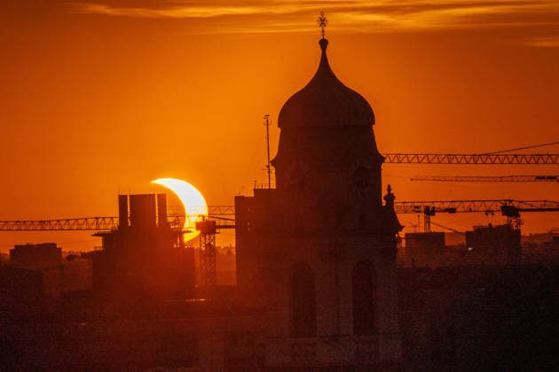 Partielle Sonnenfinsternis kurz nach ihrem Höhepunkt um 20:29 Uhr, Sonnensichel versinkt hinter dem Horizont neben dem Kirchturm von St. Wolfgang, Stadtteil Haidhausen, München, 12. August 2026 Deutschland, München, 12. August 2026, partielle Sonnenfinsternis kurz nach ihrem Höhepunkt um 20:29 Uhr, Sonnensichel versinkt neben dem markanten Zwiebelturm von St. Wolfgang in Haidhausen, der Mond schiebt sich vor die tiefstehende Sonne und deckt sie zu 89 Prozent ab, Sonnensichel kurz vor dem Sonnenuntergang um 20:32 Uhr, der Münchner Abendhimmel leuchtet in Orange, Blick von einem Hochhaus an der Rosenheimer Straße stadteinwärts, die katholische Pfarrkirche St. Wolfgang wurde 1920 eingeweiht, Astronomie, Sommer, Bayern, bayerisch, *** Pa