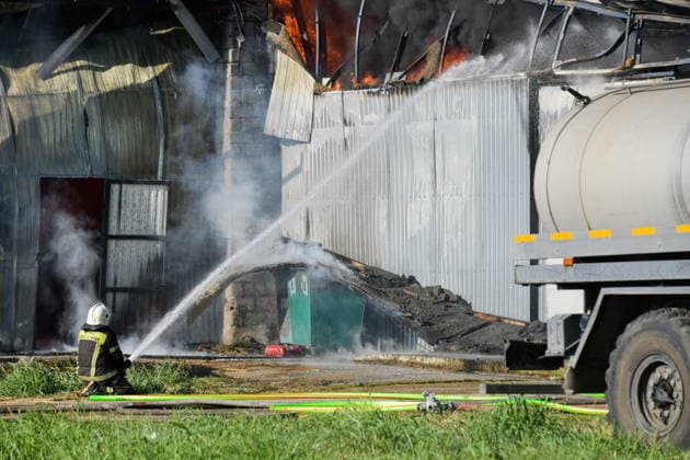 RUSSIA, KRASNODAR REGION - AUGUST 12, 2026: An employee of the Russian Emergencies Minsitry extinguishes a fire at a warehouse storing plastic products in the village of Lenina, southeast of Krasnodar. The fire covering an area of 2.2 thousand sq m has been contained. Roman Sokolov TASS  96070032