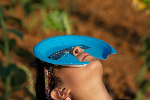 August 12, 2026, Sahagun, Leon, Spain: A girl wearing eclipse glasses looks at the sky, during a total solar eclipse in a sunflower field in the town of Sahagun, Castile and Leon, Spain. Sahagun Spain - ZUMAs296 20260812_znp_s296_005 Copyright: xLuisxSotox