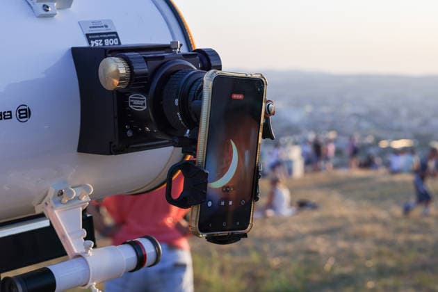 Sonnenfinsternis, Lörrach, Sonnenfinsternis 2026, partielle Sonnenfinsternis, Sonnenbeobachtung, Astronomie, Teleskop, Smartphone, Handyfotografie, Astrofotografie, Sonnenfotografie, Sonnenfinsternis fotografieren, Sonnenfinsternis Aufnahme, Sonnensichel, teilweise bedeckte Sonne, Mond vor der Sonne, Himmelsereignis, astronomisches Ereignis, Teleskopaufnahme, Smartphone am Teleskop, Okular, Teleskoptechnik, Beobachtungsgerät, Wissenschaft, Weltraum, Himmel, Abendstimmung, Sonnenuntergang, goldenes Licht, Zuschauer, öffentliche Beobachtung, Baden-Württemberg, Deutschland, Dreiländereck, Technik, Fotografie, Dokumentation, Nahaufnahme Lörrach Tüllingerberg Deutschland *** Solar eclipse, Lörrach, 2026 solar eclipse, partial solar eclip Copyright: xGrantxHubbsx