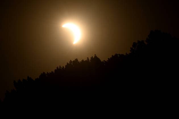 Die partielle Sonnenfinsternis hinter einer Braumkrone, Menschen beobachten die partielle Sonnenfinsternis und stehen dabei auf der Ripshorstbruecke ueber den Rhein-Herne-Kanal, 12.08.2026 in Oberhausen. *** The partial solar eclipse viewed through a beer foam crown; people watch the partial solar eclipse while standing on the Ripshorst Bridge over the Rhine-Herne Canal, August 12, 2026, in Oberhausen