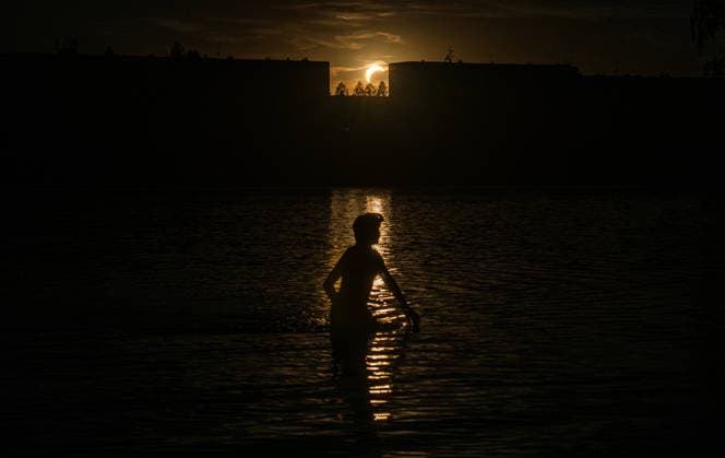 Boy is swimming during the partial solar eclipse in Mseno dam in Jablonec nad Nisou, Czech Republic, August 12, 2026. (CTKxPhoto RomanxVondrous) CTKPhotoP2026081207991  CTKPhotoP2026081207991