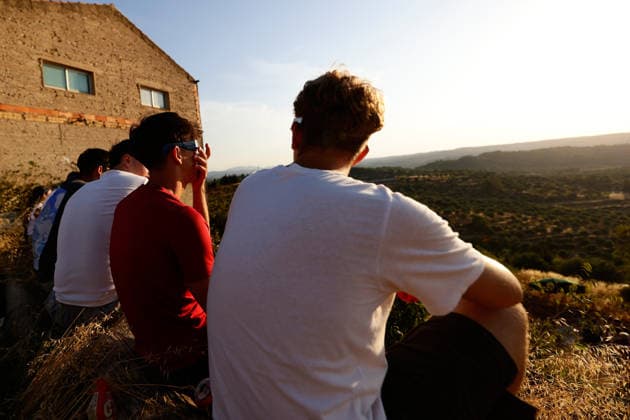 The Perfect Alignment Of The Moon And The Sun During The Total Solar Eclipse Of 2026 A group of tourists and outdoor enthusiasts look up with protective eyewear at the solar corona during totality in Horta de Sant Joan, Spain, on August 12, 2026. The solar corona illuminates the sky over the mountain peaks of Els Ports Natural Park during the eclipse. Horta de Sant Joan Catalonia Spain  Copyright: xJoanxCrosx originalFilename: cros-notitle260812_npgO8.jpg