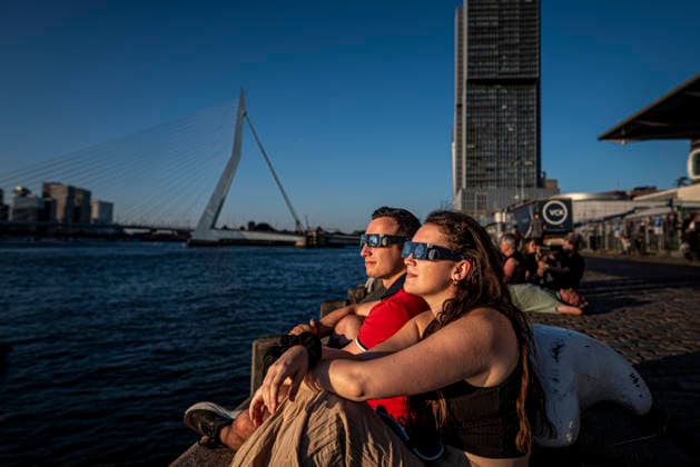August 12, 2026, Rotterdam, South Holland, The Netherlands Holland: A couple watches as a solar eclipse makes its way over Holland. 12 August 2026, Rotterdam, the Netherlands. Hundreds of Dutch spectators witnessed a partial solar eclipse seen from the Wilhelminapier as the Moon blocked nearly 90% of the Sun over the Nieuwe Maas. Rotterdam The Netherlands Holland - ZUMAp202 20260812_zip_p202_007 Copyright: xJamesxPetermeierx