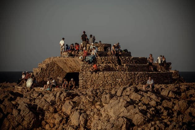 August 12, 2026, Ciutadella, Balearic Islands Menorca, Spain: People gather on stone ruins at Punta Nati to watch a total solar eclipse on the Spanish Balearic island of Menorca. Ciutadella Spain - ZUMAo105 20260812_fap_o105_006 Copyright: xMatthiasxOesterlex