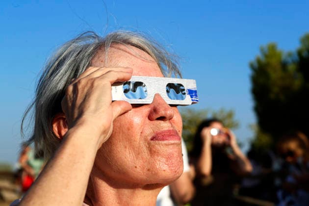 August 12, 2026, Madrid, Community Of Madrid, Spain: A massive crowd of astronomy enthusiasts and families gathers in the elevated grounds of the Parque Forestal de Valdebebas Felipe VI in Madrid, united by the anticipation of the first total solar eclipse visible from the Spanish mainland in 114 years. As the historic celestial event reaches its peak, the atmosphere in the park remains focused and disciplined; attendees are seen equipped with government-distributed, ISO 12312-2 certified solar glasses to safely observe the Sun s occlusion by the Moon. The choice of this expansive public park, with its unobstructed horizon and minimal urban light pollution, offers thousands of spectators a prime vantage point to witness the transition of da - ZUMAo127 20260812_zep_o127_059 Copyright: xHugoxOrtunox