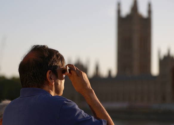 (260812) -- LONDON, Aug. 12, 2026 -- A man observes the partial solar eclipse in London, Britain, Aug. 12, 2026. ) BRITAIN-LONDON-SOLAR ECLIPSE LixYing 