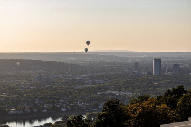 Partielle Sonnenfinsternis am Petersberg im Siebengebirge - 12.08.2026. Aufsteigende Heißluftballons über der Rheinaue in Bonn - Blick vom Petersberg im Siebengebirge (Königswinter) über Bonn und Köln hinweg auf die partielle Sonnenfinsternis am Abend des 12. August 2026: Der Mond bedeckt die Sonne zu bis zu 89 Prozent. Königswinter Petersberg Nordrhein-Westfalen Deutschland *** Partial solar eclipse at Petersberg in the Siebengebirge on August 12, 2026; hot-air balloons rising over the Rheinaue in Bonn; view from Petersberg in the Siebengebirge near Königswinter, looking out over Bonn and Cologne toward the partial solar eclipse on the evening of August 12 2026 The Moon covers up to 89 percent of the Sun Königswinter Petersberg North Copyright: xMarcxJohnx