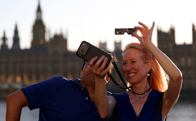 (260812) -- LONDON, Aug. 12, 2026 -- People pose for selfies during a partial solar eclipse in London, Britain, Aug. 12, 2026. ) BRITAIN-LONDON-SOLAR ECLIPSE LixYing 