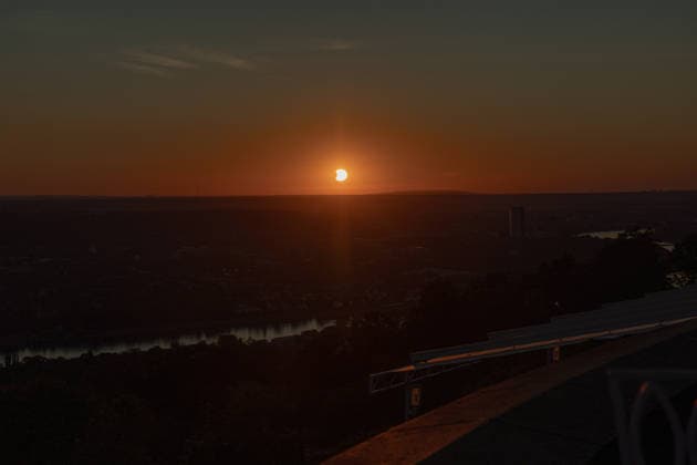 Partielle Sonnenfinsternis am Petersberg im Siebengebirge - 12.08.2026. Blick vom Petersberg im Siebengebirge (Königswinter) über Bonn und Köln hinweg auf die partielle Sonnenfinsternis am Abend des 12. August 2026: Der Mond bedeckt die Sonne zu bis zu 89 Prozent. Sonne und Mond gehen gemeinsam in einer Sichtachse hinter dem rund 58 Kilometer entfernten Hambacher Forst mit seinen zahlreichen Windkraftanlagen unter. Königswinter Petersberg Nordrhein-Westfalen Deutschland *** Partial Solar Eclipse at Petersberg in the Siebengebirge on August 12, 2026: View from Petersberg in the Siebengebirge near Königswinter, looking across Bonn and Cologne toward the partial solar eclipse on the evening of August 12, 2026. The Moon covers the Sun by up Copyright: xMarcxJohnx