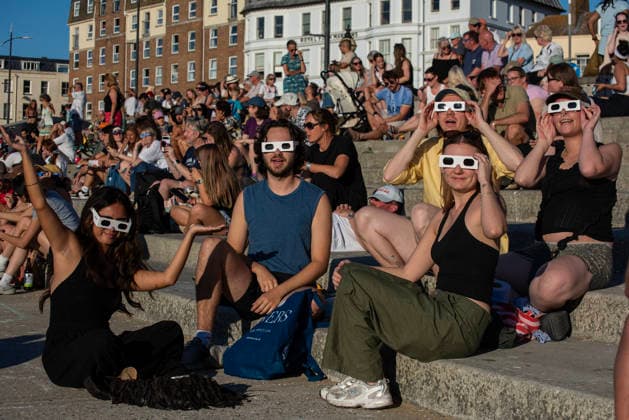 Solar Eclipse 2026 in Margate, UK - 12 AUG 2026. A group of friends seen enjoying the solar eclipse in their glasses. Hundreds of people gathered on the King s Steps to enjoy the partial solar eclipse in Margate, UK. Because of the Sun was covered by the Moon 90.6% on the maximum phase of the partial solar eclipse. Margate United Kingdom Copyright: xKrisztianxElekx xSOPAxImagesx SSS_20260812_SOLAR_ECLIPSE_0011005010