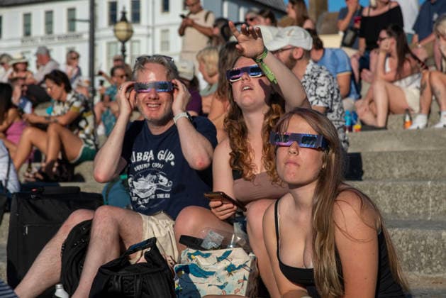 Solar Eclipse 2026 in Margate, UK - 12 AUG 2026. A group of friends seen enjoying the solar eclipse in their glasses. Hundreds of people gathered on the King s Steps to enjoy the partial solar eclipse in Margate, UK. Because of the Sun was covered by the Moon 90.6% on the maximum phase of the partial solar eclipse. Margate United Kingdom Copyright: xKrisztianxElekx xSOPAxImagesx SSS_20260812_SOLAR_ECLIPSE_0011005032