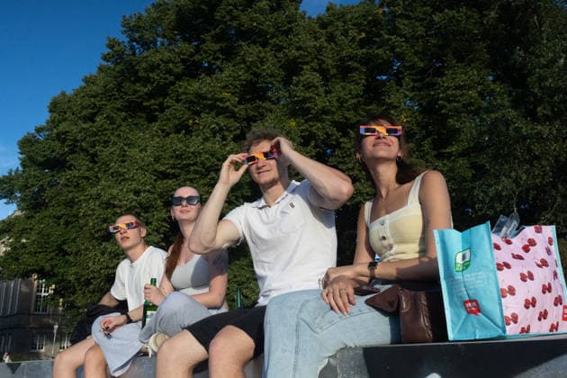 Partial Solar eclipse in Leipzig, Germany - 12 Aug 2026 People wearing eclipse glasses watch the partial solar eclipse from the Angerstrasse bridge in Leipzig. Residents gathered in the evening to observe the Moon move across the face of the Sun. The eclipse began at 7:17 p.m. CEST and reached its maximum over the city at 8:10 p.m. Leipzig Germany Copyright: xVasilyxKrestyaninovx xSOPAxImagesx _VKR9085