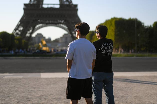 Paris: The public watches the solar eclipse. People on the Champ de Mars watch through solar eclipse viewing glasses as the moon completely passes over the sun s horizon during a partial solar eclipse in Paris on August 12, 2026. 458857 2026 08 12 Paris, France. No people in the frame.  Copyright: xL.Urmanx xStarfacex STAR_458857_004