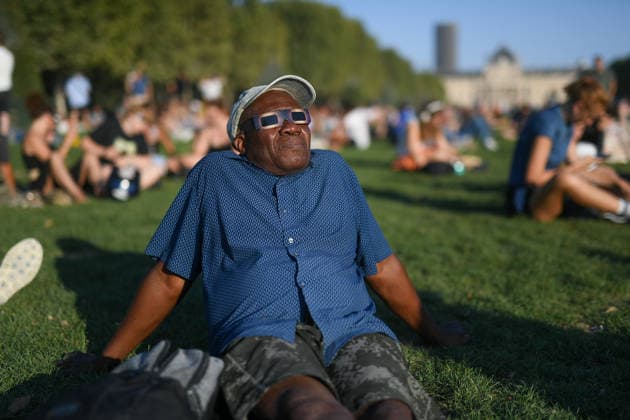 Paris: The public watches the solar eclipse. People on the Champ de Mars watch through solar eclipse viewing glasses as the moon completely passes over the sun s horizon during a partial solar eclipse in Paris on August 12, 2026. 458857 2026 08 12 Paris, France. No people in the frame.  Copyright: xL.Urmanx xStarfacex STAR_458857_005