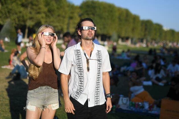 Paris: The public watches the solar eclipse. People on the Champ de Mars watch through solar eclipse viewing glasses as the moon completely passes over the sun s horizon during a partial solar eclipse in Paris on August 12, 2026. 458857 2026 08 12 Paris, France. No people in the frame.  Copyright: xL.Urmanx xStarfacex STAR_458857_009