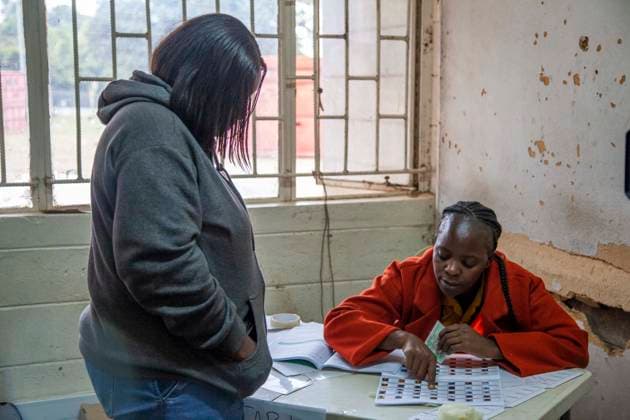 (260813) -- LUSAKA, Aug. 13, 2026 -- A staff member checks a voter s identity at a polling station in Lusaka, Zambia, on Aug. 13, 2026. Zambia held general elections on Thursday, with about 8.7 million registered voters casting ballots for president, National Assembly members and local representatives. (Photo by Xinhua) ZAMBIA-GENERAL ELECTIONS-VOTING MartinxMbangweta 